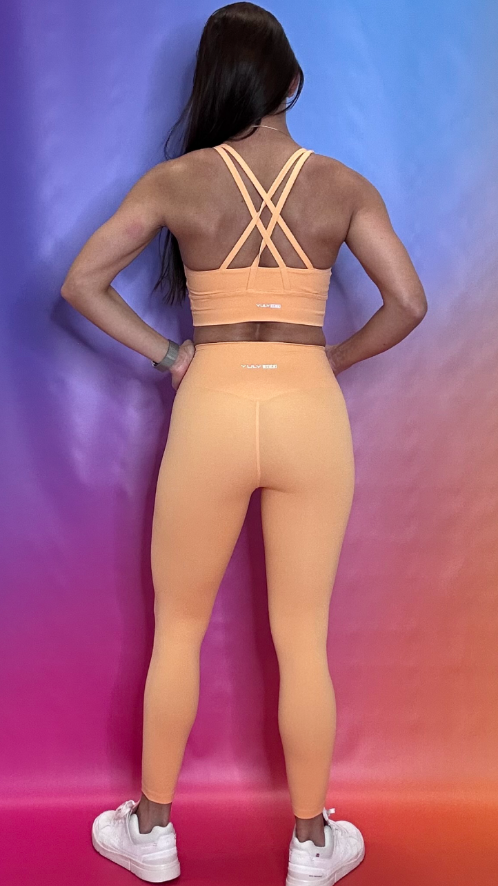 Back view of Hustle Bra in orange — breathable and flexible athletic bra