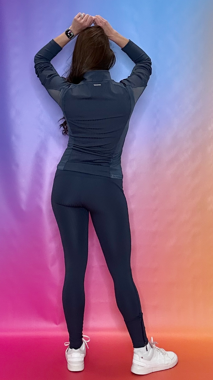Model full body back view wearing Enclave Jacket navy and Enclave Leggings — sleek gym to street activewear