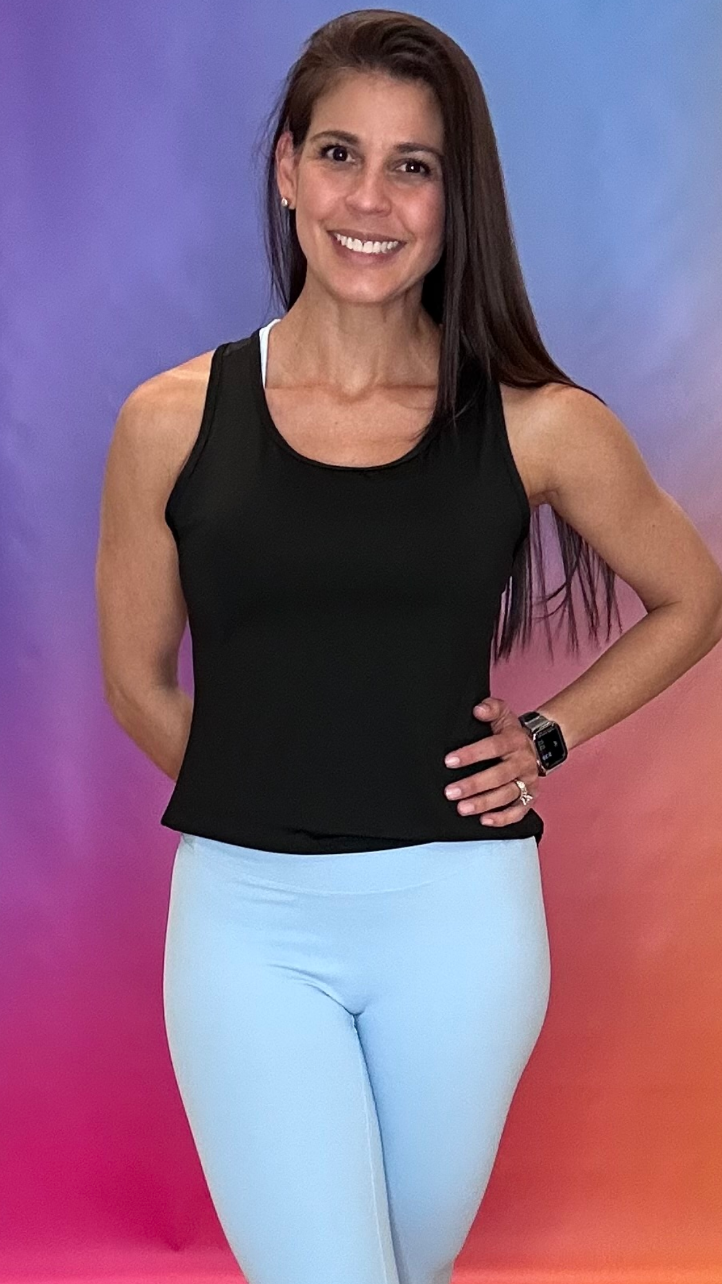 Front view of woman wearing black Sparkle Tank Top with light blue leggings